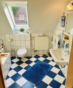 a bathroom with a toilet and a sink at Ferienwohnung DE VRIESenkoje in Südbrookmerland +29 photos