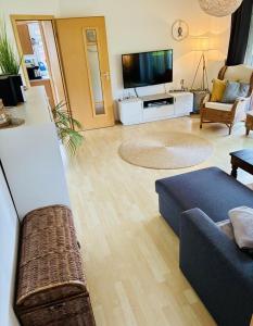 a living room with a couch and a tv at Ferienwohnung DE VRIESenkoje in Südbrookmerland