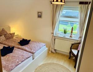 a bedroom with a bed and a window and a chair at Ferienwohnung DE VRIESenkoje in Südbrookmerland