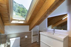 a bathroom with a sink and a skylight at Refugio del Roble by BeValle in Panticosa