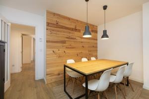 a dining room with a wooden wall and a table and chairs at Acentor Alpino by BeValle in Panticosa