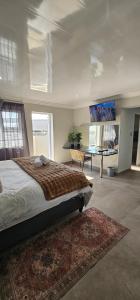 a bedroom with a bed and a desk in it at Lion Lodge in Bloemfontein
