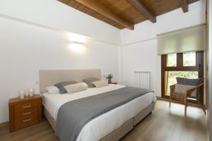 a white bedroom with a large bed and a window at Sueños del Garmo by BeValle in Panticosa +39 photos