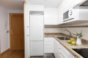 a white kitchen with a refrigerator and a sink at Ripereta by BeValle in Panticosa +17 photos
