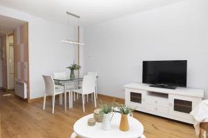 a living room with a table and a flat screen tv at Ripereta by BeValle in Panticosa