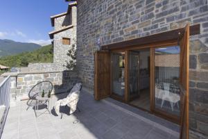 a stone house with a patio with a table and chairs at Aura de Gavin by BeValle in Buesa +35 photos