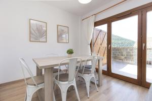 a dining room with a wooden table and chairs at Aura de Gavin by BeValle in Buesa
