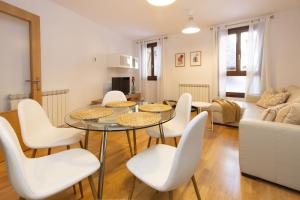 a living room with a table and white chairs at Calma by BeValle in Panticosa
