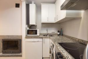 a white kitchen with a sink and a microwave at Calma by BeValle in Panticosa