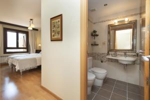 ein Badezimmer mit Toilette, Waschbecken und Bett in der Unterkunft Refugio del Valle by BeValle in Panticosa