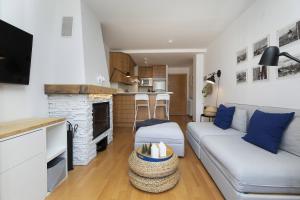 a living room with a couch and a kitchen at PanticAsa Azul by BeValle in Panticosa