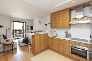 a kitchen with wooden cabinets and a living room at PanticAsa Azul by BeValle in Panticosa