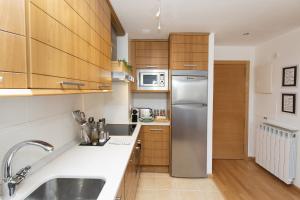 a kitchen with wooden cabinets and a stainless steel refrigerator at PanticAsa Azul by BeValle in Panticosa