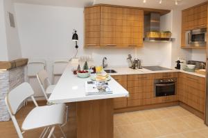 a kitchen with a white counter and wooden cabinets at PanticAsa Azul by BeValle in Panticosa +16 photos