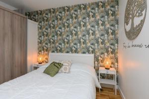 a bedroom with a white bed and a wall mural at Laïta - Séjour à Quimperlé in Quimperlé
