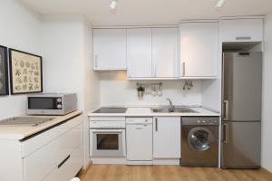 a kitchen with white cabinets and a sink and a dishwasher at Casa Abedul by BeValle in Panticosa +15 photos