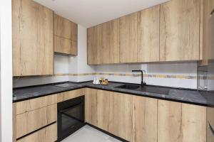 a kitchen with wooden cabinets and a sink at Casa Lite by BeValle in Escarrilla