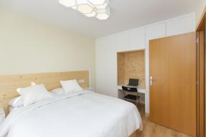 a bedroom with a large white bed and a desk at Casa Lite by BeValle in Escarrilla