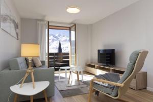 a living room with a couch and a tv at La Ventana de Formigal by BeValle in Formigal
