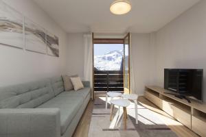 a living room with a couch and a tv at La Ventana de Formigal by BeValle in Formigal
