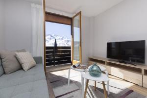 a living room with a large television and a couch at La Ventana de Formigal by BeValle in Formigal +22 photos