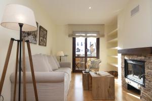 a living room with a white couch and a fireplace at CuMbre del Sarrio by BeValle in Panticosa