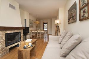 a living room with a white couch and a fireplace at CuMbre del Sarrio by BeValle in Panticosa