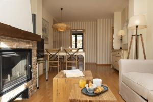 a living room with a fireplace and a table at CuMbre del Sarrio by BeValle in Panticosa