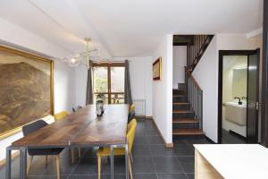 a dining room with a wooden table and yellow chairs at Casa Vity by BeValle in Panticosa