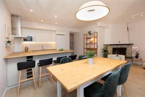 a kitchen and dining room with a wooden table and chairs at Casa Josephine by BeValle in Panticosa +13 photos