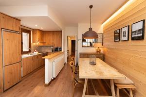 a kitchen with wooden cabinets and a wooden table at El Mirador by BeValle in Panticosa
