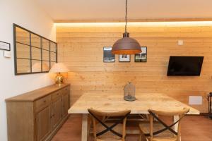a dining room with a wooden table and a television at El Mirador by BeValle in Panticosa
