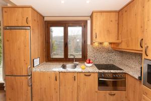 a kitchen with wooden cabinets and a sink and a window at El Mirador by BeValle in Panticosa +22 photos