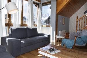 a living room with a couch and a table at Ático de Pao by BeValle in Panticosa