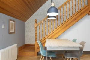a dining room with a table and chairs and a staircase at Ático de Pao by BeValle in Panticosa +32 photos