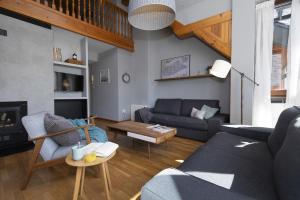 a living room with a couch and a table at Ático de Pao by BeValle in Panticosa
