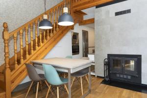 a dining room with a table and chairs and a fireplace at Ático de Pao by BeValle in Panticosa