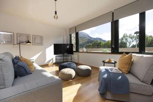 a living room with a couch and a large window at La Ventana de Saras by BeValle in Panticosa
