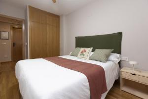 a bedroom with a large white bed with a green headboard at Balaitus by BeValle in Escarrilla