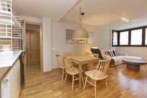 a living room with a table and chairs and a couch at Balaitus by BeValle in Escarrilla +17 photos
