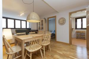 a dining room and living room with a table and chairs at Balaitus by BeValle in Escarrilla