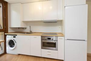 a white kitchen with a refrigerator and a dishwasher at TenaNatura Ski by BeValle in Escarrilla