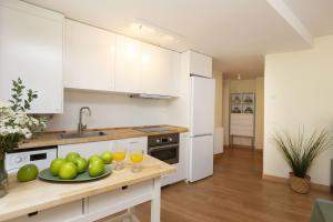 a kitchen with white cabinets and a plate of fruit on a counter at TenaNatura Ski by BeValle in Escarrilla