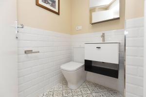 a white bathroom with a toilet and a mirror at Montibel by BeValle in Panticosa