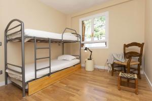 a bedroom with two bunk beds and a chair at Montibel by BeValle in Panticosa