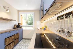 a large kitchen with blue cabinets and a sink at Montibel by BeValle in Panticosa +19 photos