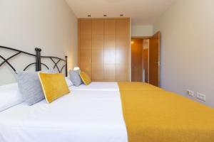 a bedroom with a large bed with a yellow blanket at Senda by BeValle in Panticosa