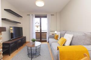 a living room with a couch and a tv at Senda by BeValle in Panticosa