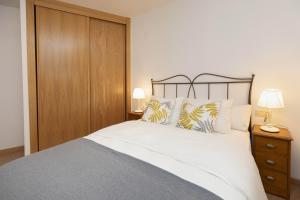 a bedroom with a large bed and a wooden cabinet at Rincón del Pueyo by BeValle in El Pueyo de Jaca