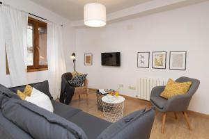 a living room with a blue couch and two chairs at Rincón del Pueyo by BeValle in El Pueyo de Jaca